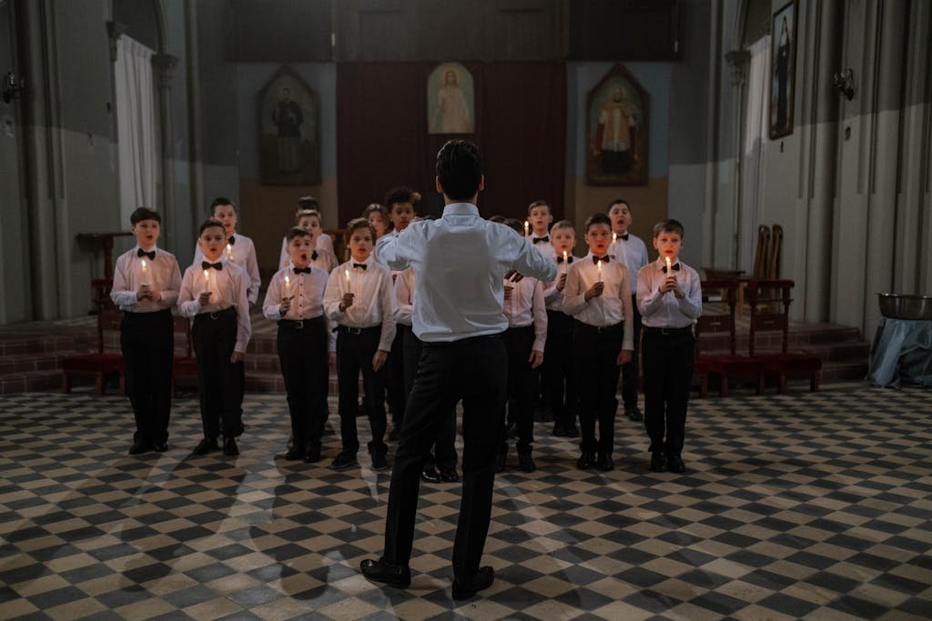 Man Standing in Front of Group of Boys Holding Lighted Candles